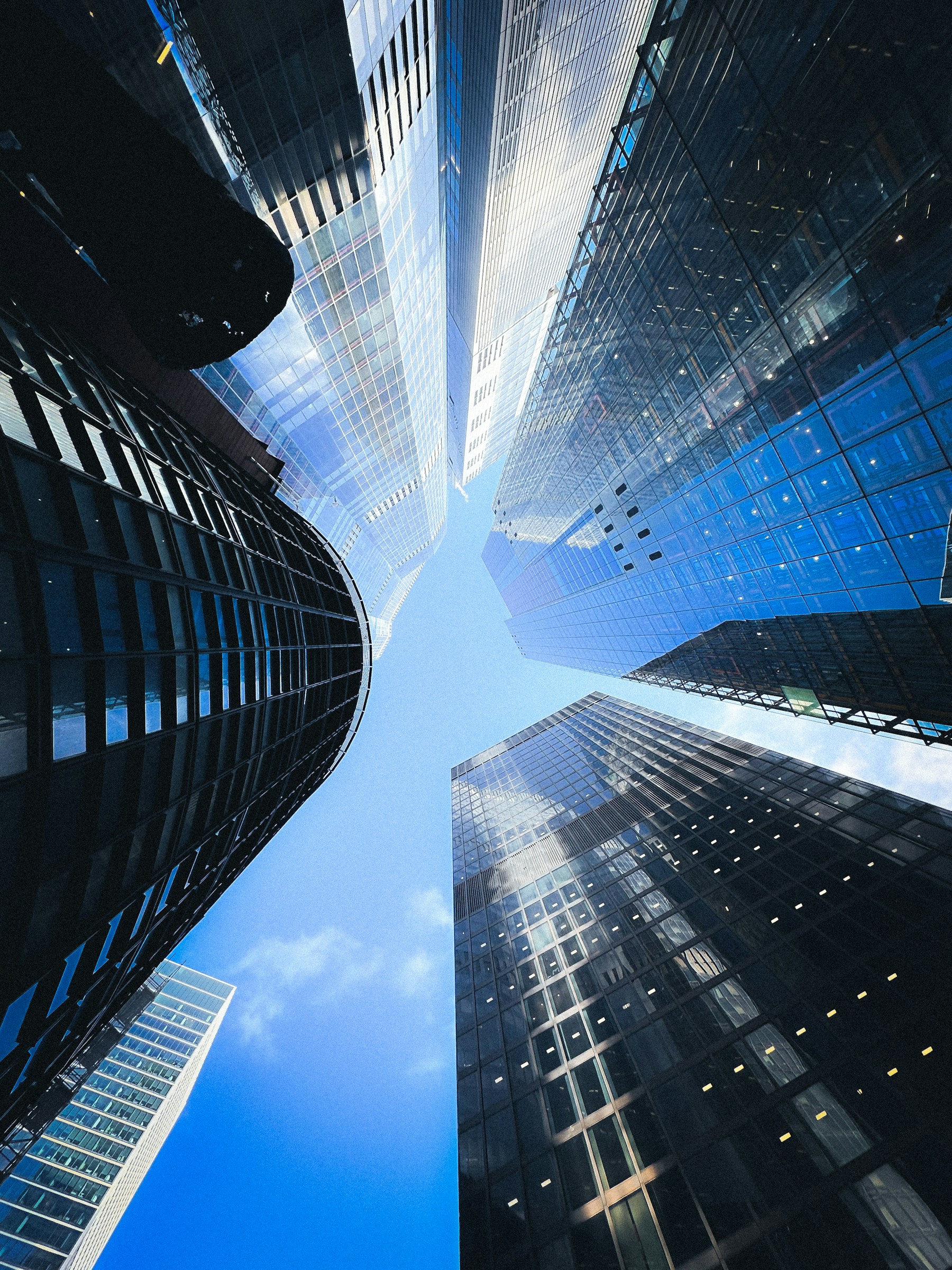 Glass towers rising into an open blue sky